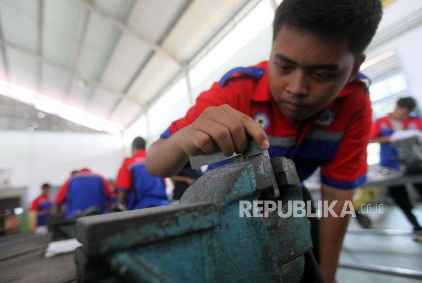 Siswa Sekolah Menengah Kejuruan (SMK) mengukur benda kerjanya saat praktik mesin di SMK Negeri 1, Jakarta, Senin (1/10).