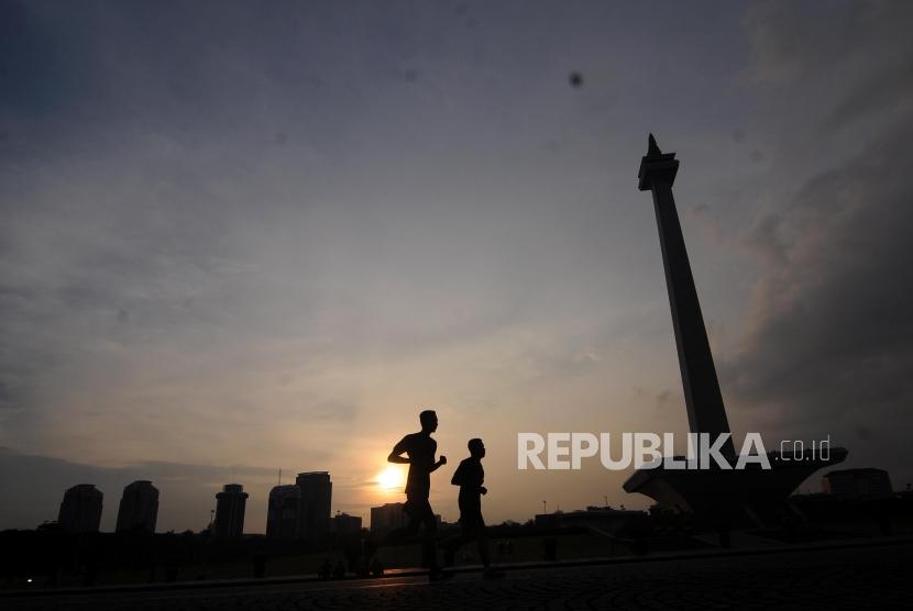 Warga saat melakukan jogging di Lapangan Monas, Jakarta, Jumat (2/2). Rutin berolahraga beberapa kali dalam sepekan dapat menjaga kebugaran tubuh.
