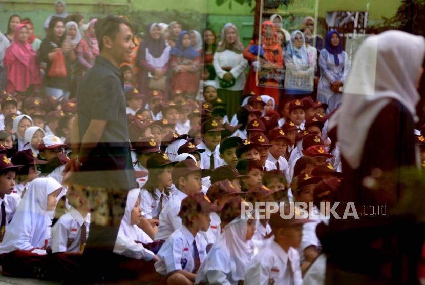 Orang tua murid mengawasi anaknya pada hari pertama masuk sekolah di SDN Kampung Melayu 01/02, Jakarta, Senin (16/7).