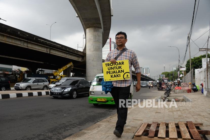 Tamasya Trotoar. Aktivis Koalisi Pejalan Kaki melakukan aksi simpatik di Kawasan Farmawati, Jakarta, Jumat (1/3).