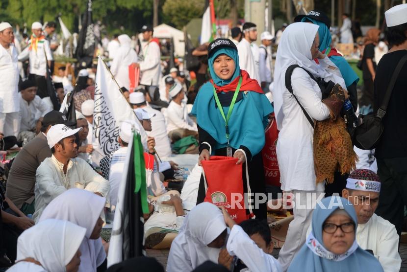 Relawan reuni 212 melakukan pengambilan infaq dari peserta  reuni aksi 212 di Lapangan Monumen Nasional, Jakarta, Ahad, (2/12).