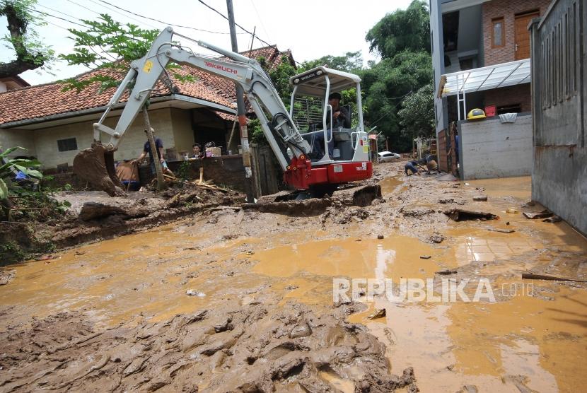 Sebuah backhoe diturunkan untuk membersihkan jalan di sebuah komplek perumahan yang dipenuhi lumpur pasca banjir bandang di daerah Jatihandap, Kota Bandung, Rabu (21/3).