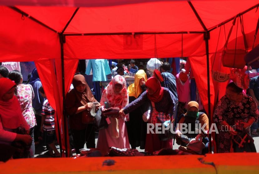 Warga yang melihat-lihat tas distan pedagang kaki lima di Kawasan Tanah Abang, Jakarta, Senin (25/12).