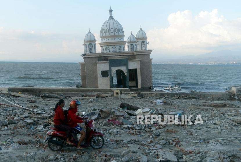 Pengendara motor melintas didekat Masjid Arwan Bab Al Rahman yang hancur di kawasan Pantai Talise, Palu, Sulawesi Tengah, Selasa (2/10).