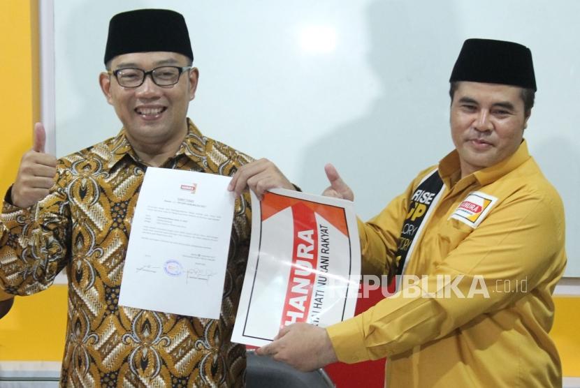 Ketua DPD Partai Hanura Jawa Barat Aceng Fikri (kanan) menyerahkan surat tugas kepada Bakal Calon Gubernur Jawa Barat Ridwan Kamil, di Kantor Hanura Jawa Barat, Jalan Moch Ramdhan, Kota Bandung, Selasa (2/1).