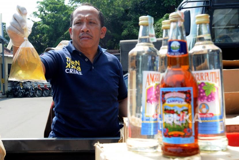 Sejumlah petugas kepolisian merapihkan barang bukti minuman keras di Polres Jakarta Selatan, Kebayoran Baru, Jakarta Selatan, Rabu (11/4).