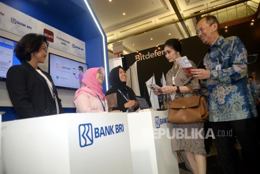 Direktur Digital Banking dan Teknologi Informasi BRI Indra Utoyo (kanan) dan Direktur Konsumer BRI Handayani (kedua kanan) berbincang dengan penjaga Stand BRI dalam pameran BRI Indocomtech 2017 di JCC, Jakarta, Rabu (1/11).