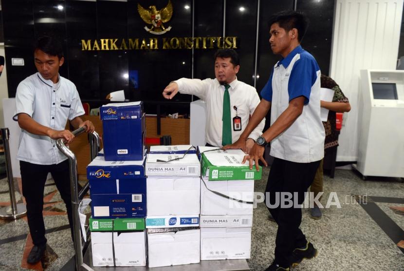 Petugas membawa berkas bukti gugatan dari Badan Pemenangan Nasional (BPN) di Gedung Mahkamah Konstitusi, Jakarta, Kamis (13/6).