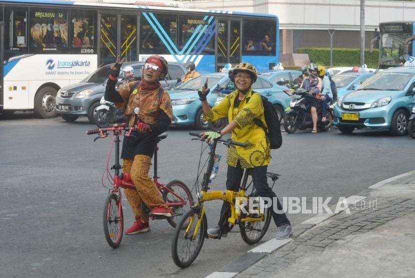 Peseda mengenakan pakaian batik saat bersepeda di kawasan Bundaran Hotel Indonesia, Jakarta Pusat, Selasa (2/10).