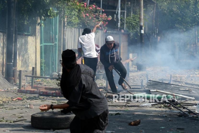 Sejumlah massa berhadapan dengan anggota brimob saat terjadi kerusuhan di Jalan Jatibaru Raya, Tanah Abang, Jakarta, Rabu (22/5).