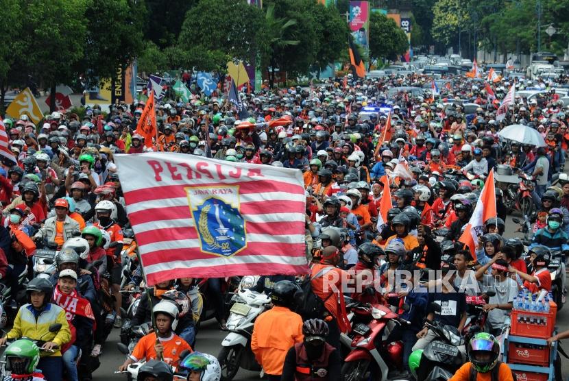 Sejumlah Suporter Persija melakukan pawai menuju Balaikota di Kawasan Senayan, Jakarta, Ahad (18/2).