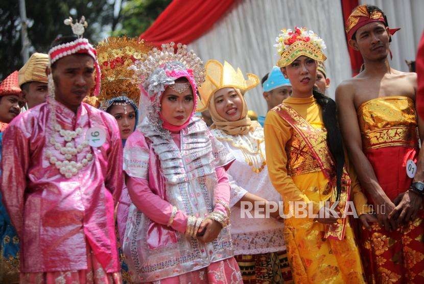 Sejumlah pasangan calon pengantin bersiap untuk ijab kabul saat nikah massal pada acara puncak Milad ke-25 tahun Dompet Dhuafa di Tugu Proklamasi, Jakarta, Sabtu (22/9).
