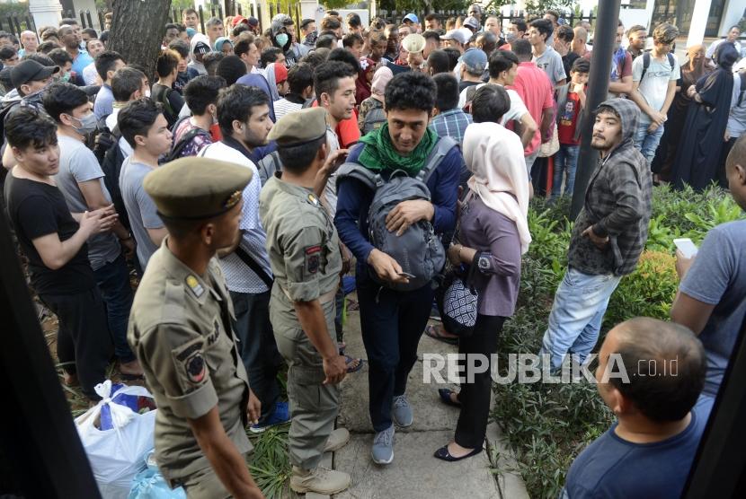 Sejumlah pencari suaka saat akan berangkat untuk dipindahkan di kawasan Kebon Sirih, Jakarta, Kamis (11/7).