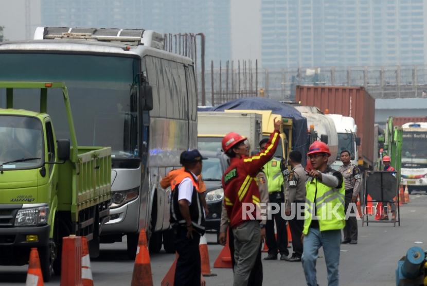 Petugas mengatur lalu lintas saat terjadi kemacetan di ruas jalan Tol Jakarta-Cikampek di Wilayah Kota Bekasi, Jawa Barat, Kamis (16/11).