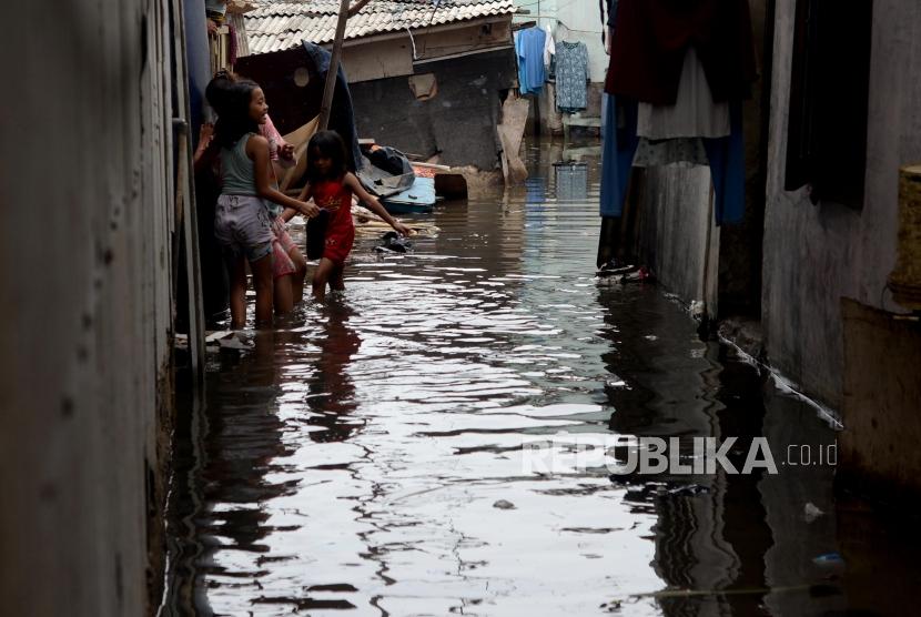 Anak-anak  bermain ditengah genangan aie banjir rob yang menggenangi Kampung Nelayan Muara Angke di Penjaringan, Jakarta, Senin (26/11).