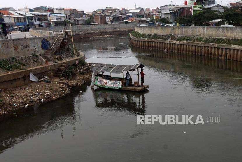 Warga menggunakan perahu eretan melintasi Sungai Ciliwung, Kawasan Jatinegara, Jakarta, Jumat (14/9).