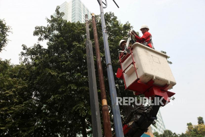 Pekerja membongkar tiang penerangan jalan umum (PJU) (ilustrasi). Pemkot Depok menerjunkan belasan personel untuk memantau kondisi PJU.