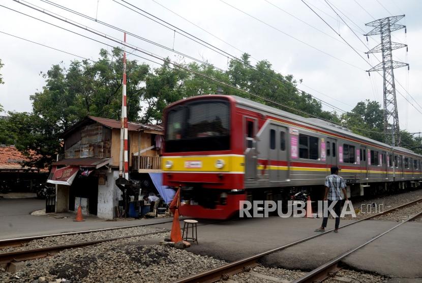 Kereta commuter line melintas di dekat perlintasan pintu kereta api yang tidak berfungsi menutup di Jalan Administrasi Negara, Bendungan Hilir, Tanah Abang, Jakarta Pusat, Senin (26/2).