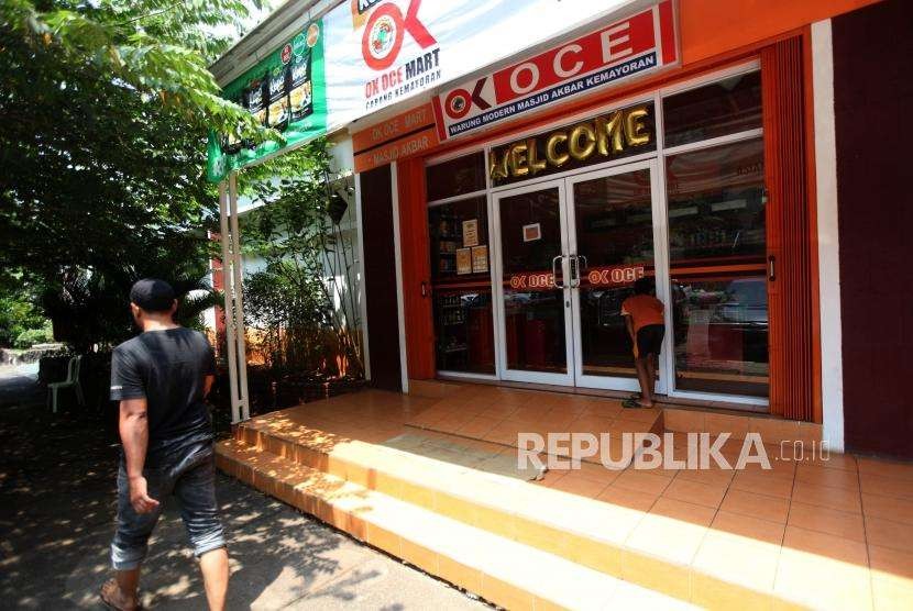 Warga melintas didepan Oke Oce Mart di Kawasan Kemayoran, Jakarta, Senin (3/9).