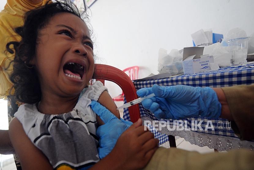 Imunisasi Massal Difteri. Seorang balita menangis saat melakukan imunisasi Difteri di Posyandu Mawar, Pancoran Mas, Kota Depok, Jawa Barat, Senin (11/12).