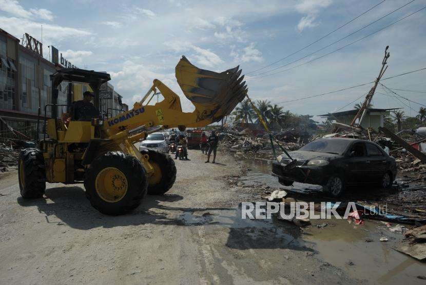 Petugas mengevakuasi mobil yang rusak di Pantai Talise, Palu, Sulawesi Tengah, Ahad (7/10).