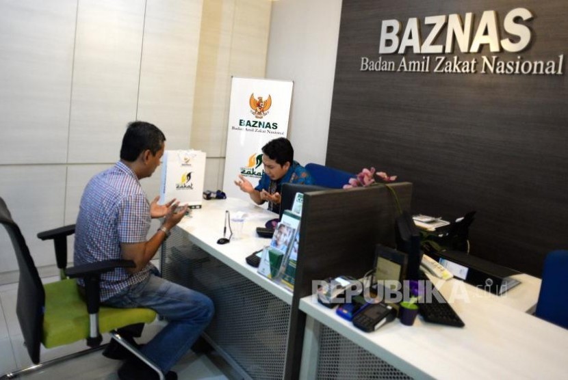 Target Penghimpunan Zakat Baznas. Muzaki membayarkan zakat dengan petugas di kantor palayanan Baznas, Jakarta, Kamis (2/11).