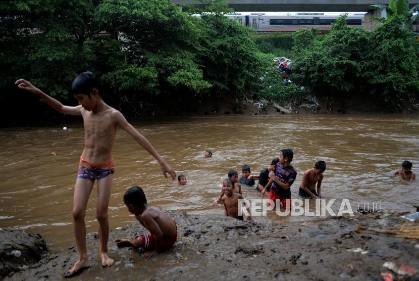 Anak-anak bermain air di aliran Sungai Ciliwung di kawasan Manggarai, Jakarta, Selasa (9/4).