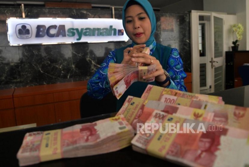 Karyawan melayani transaksi setoran nasabah di BCA Syariah. ilustrasi