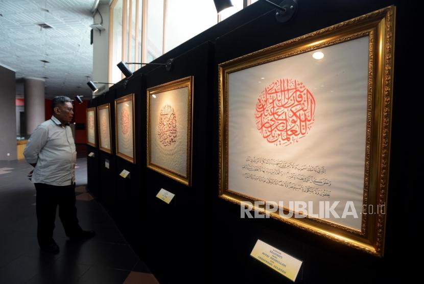 Pengujung melihat lukisan kaligrafi yang dipamerkan pada Festival Seni Kaligrafi Islam Indonesia di Gedung Bayt Al-Quran TMII, Jakarta, Senin (14/1).
