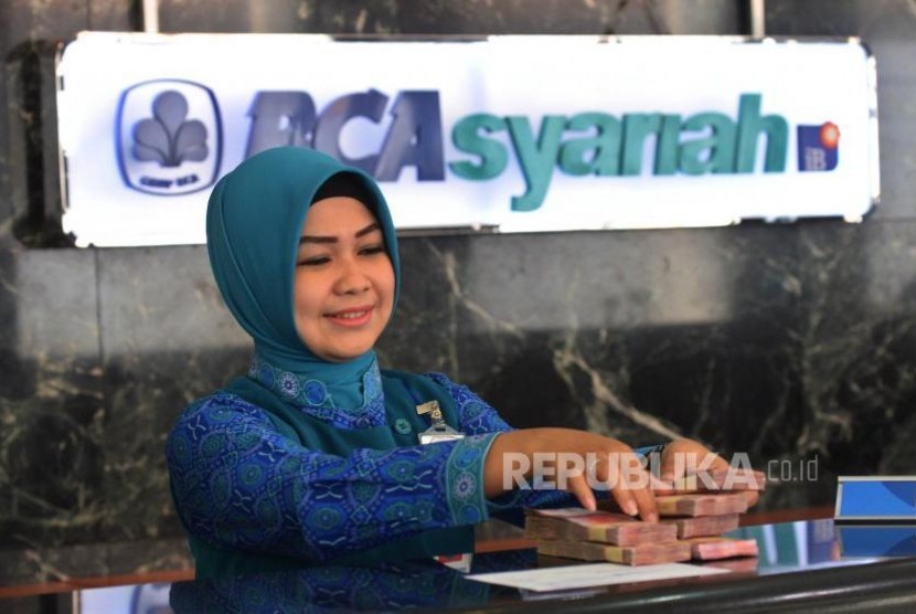 Karyawan melayani transaksi setoran nasabah di BCA Syariah (ilustrasi).