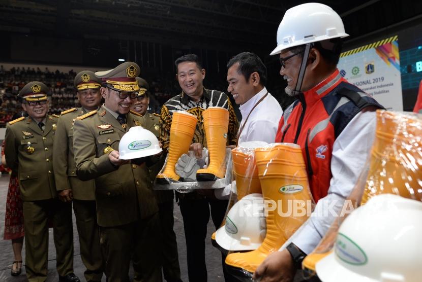 Menteri Ketenagakerjaan M. Hanif Dhakiri (keempat kanan) bersama Direktur Pelayanan BPJS Ketenagakerjaan Krishna Syarif (ketiga kanan) menyerahkan Alat Pelindung Diri (APD) kepada pekerja sektor konstruksi seusai upacara bulan K3 Nasional tahun 2019 di Jakarta, Selasa (15/1).