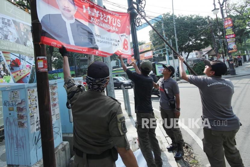 Penertiban Atribut Kampanye. Petugas Satpol PP bersama Badan Pengawas Pemilu (Bawaslu) Jawa Barat menertibkan atribut kampanye, di Jalan LRE Martadinata, Kota Bandung, Jumat (8/3).