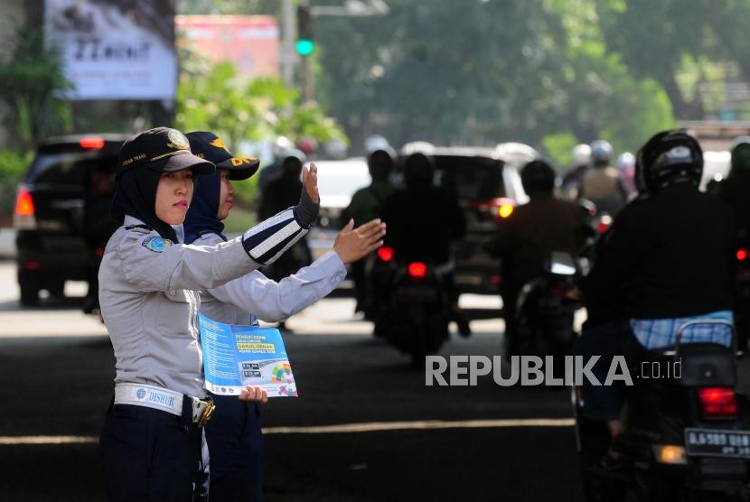 Petugas Dinas Perhubungan mengatur lalu lintas saat uji coba perluasan ganjil genap di kawasan Pancoran, Jakarta Selatan, Senin (2/7).