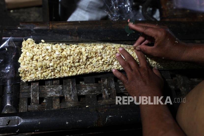 Pekerja mengemas kacang kedelai untuk dijadikan tempe. Pengusaha tahu tempe di Gorontalo mengalami penurunan pendapatan di tengah pandemi Covid-19.