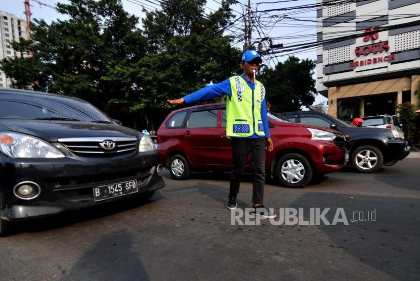 Petugas Sukarelawan Pengatur Lalu Lintas (Supeltas) saat mengatur lalu lintas di Jalan Pejompongan Raya, Tanah Abang, Jakarta Pusat, Selasa (31/10).