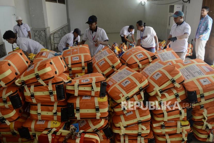Sejumlah porter merapihkan koper calon jamaah haji di Asrama Haji Pondok Gede, Jakarta, Ahad (14/7).