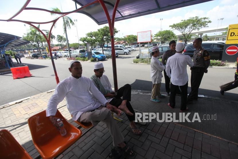 Pendukung Habib Rizieq berbincang dengan petugas polisi saat menunggu kedatangan Habib Rizieq di Bandara Soekarno-Hatta, Tangerang, Banten, Rabu (21/2).