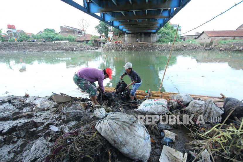 Dua penduduk berusaha mengangkat sampah Sungai Citraum, di Sektor enam program Citarum Harum Kodam III/Siliwangi, Kecamatan Bojongsoang, Kabupaten Bandung, Selasa (24/4).