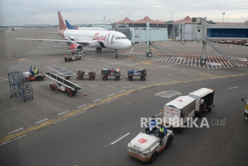 Petugas masukan barang milik penumpang ke bagasi pesawat di Bandara Internasional Soekarno,-Hatta, Tanggerang,Banten, Kamis (7/2).