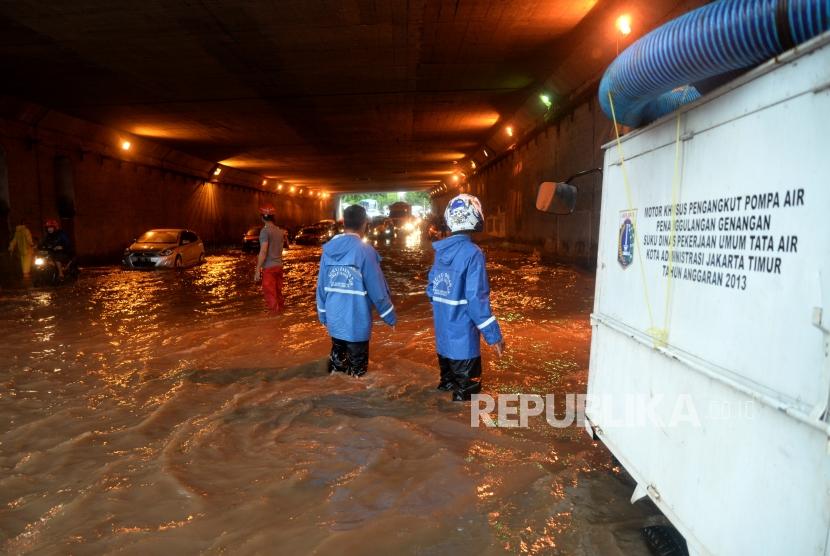 Petugas menyiapkan pompa untuk menyedot genangan air di terowongan Cawang, Jakarta, Selasa (12/12).