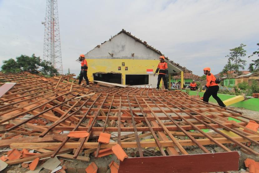 Sejumlah personel tim SAR membersihkan puing bangunan MTS Istiqomah yang roboh akibat angin puting beliung di Desa Panguragan Kulon, Kabupaten Cirebon, Jawa Barat, Senin (31/12/2018).