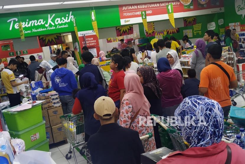 Calon pembeli mengantre untuk melakukan pembayaran di Supermarket Giant, Mampang Prapatan, Jakarta, Ahad (23/6).