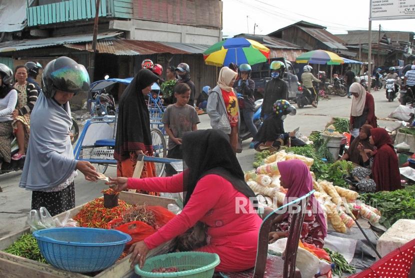 Pembeli melakukan transaksi dengan pedangan di pasar Impres Palu, Sulawesi Tengah, Sabtu (20/10).
