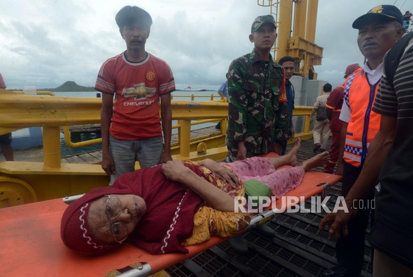 Sejumlah petugas mengevakuasi warga yang sakit di Dermaga 5 Pelabuhan Bakauheni, Lampung Selatan, Rabu (26/12).