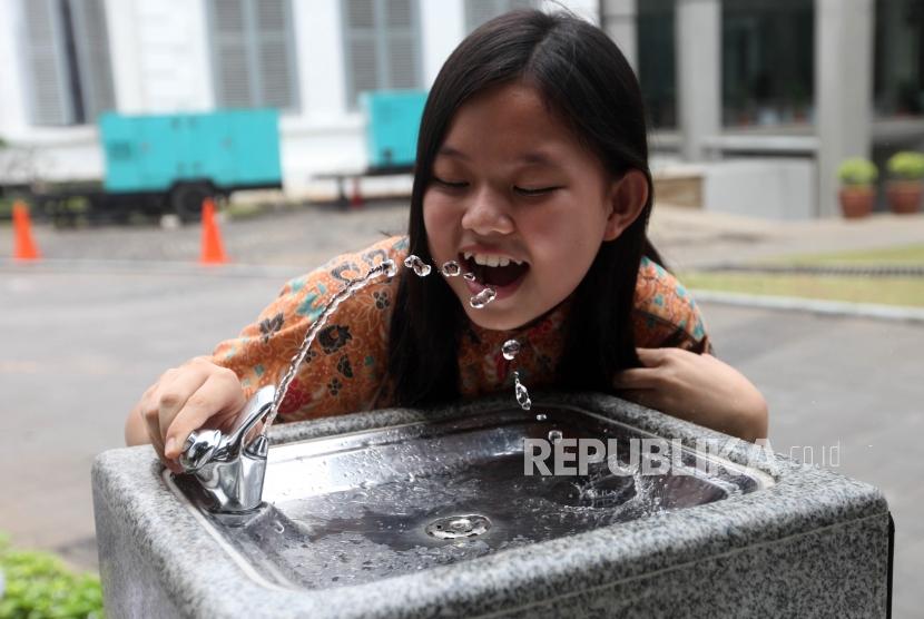 Pelajar meminum air minum di fasilitas air siap minum (Drinking Fountain) di halaman Museum Nasional, Jakarta, Jumat (9/11).