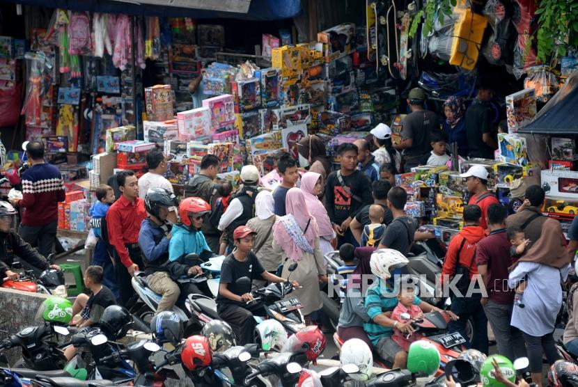 Calon pembeli memilih mainan untuk anaknya ketika berbelanja di Pasar Gembrong, Jakarta. 