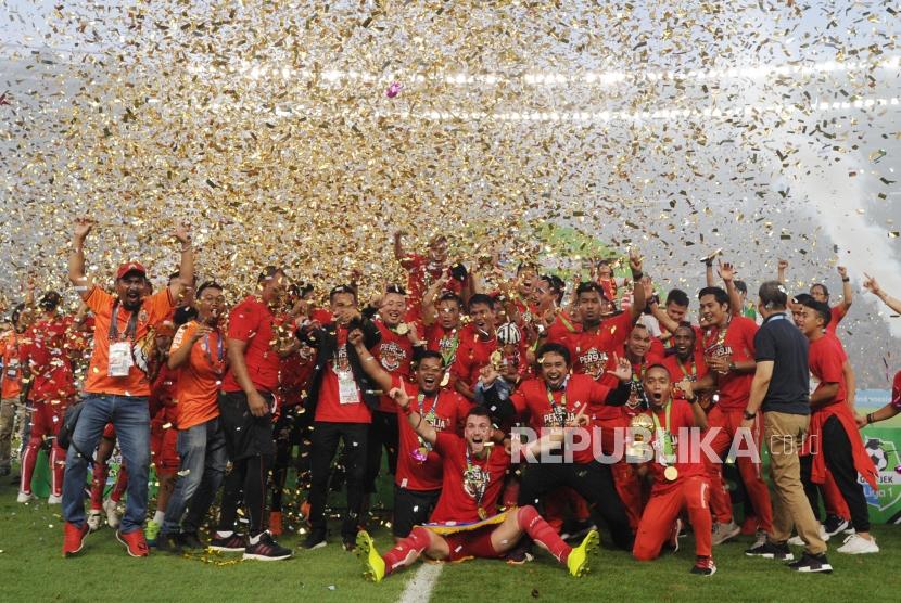 Pemain dan pengurus Persija Jakarta mengangkat piala seusai mengalahkan Mitra Kukar dalam laga Liga 1 2018 di di Stadion Utama Gelora Bung Karno, Jakarta, Ahad (9/12).