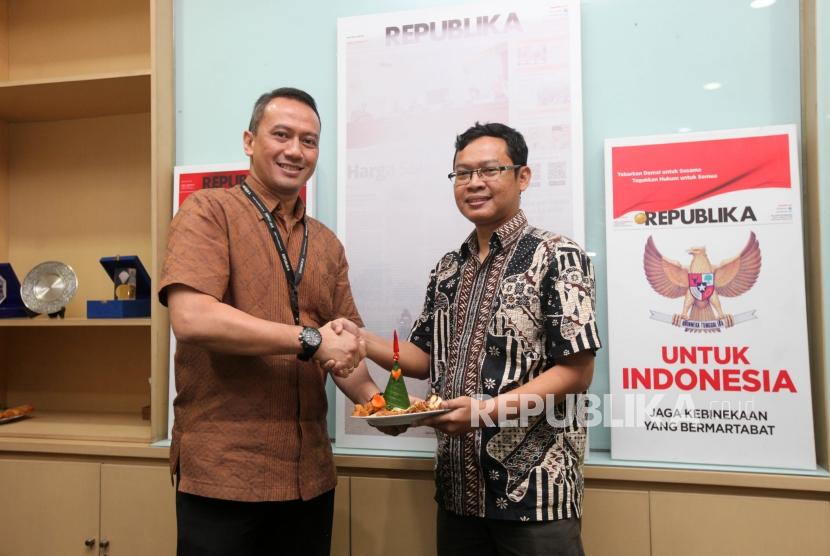 Direktur Utama Republika Media Mandiri Agoosh Yuoosran (kiri) menyerahkan potongan tumpeng kepada CEO Xeranta Mobile Heru Hariyanto (kanan) saat soft Launching Aplikasi Ihram di Kantor Harian Republika, Jakarta, Kamis (25/10).