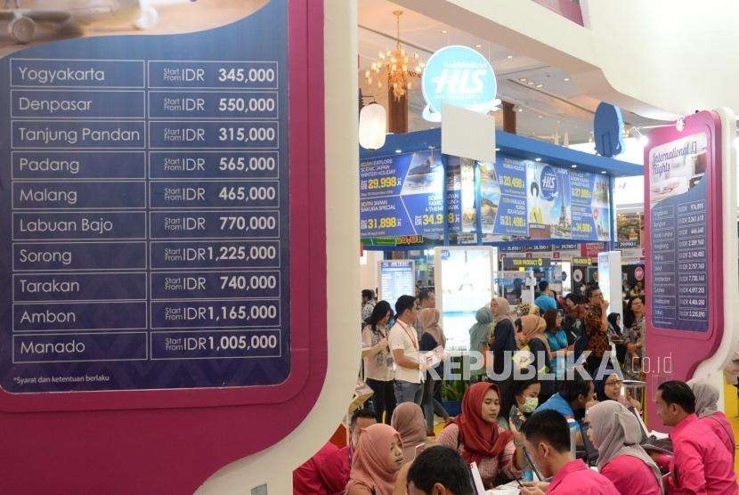 Pengunjung mencari info pemesanan tiket di salah satu stan pada Garuda Indonesia Travel Fair (GATF) phase II 2018 di Jakarta Convention Center, Jumat (5/10).