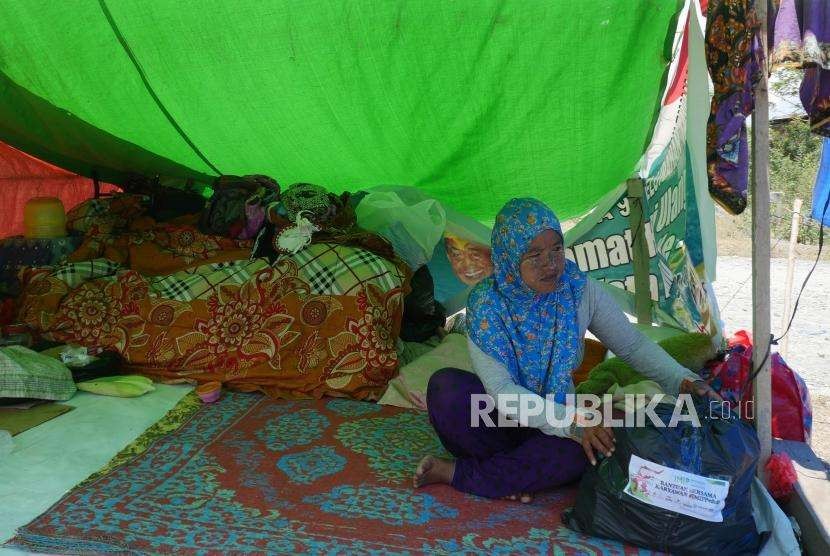 Seorang warga pengungsi menyusun paket sembako dari ACT ke dalam tenda pengunsiannya di Duyu, Palu Barat, Kecamatan Tatanga, Selasa (9/10).